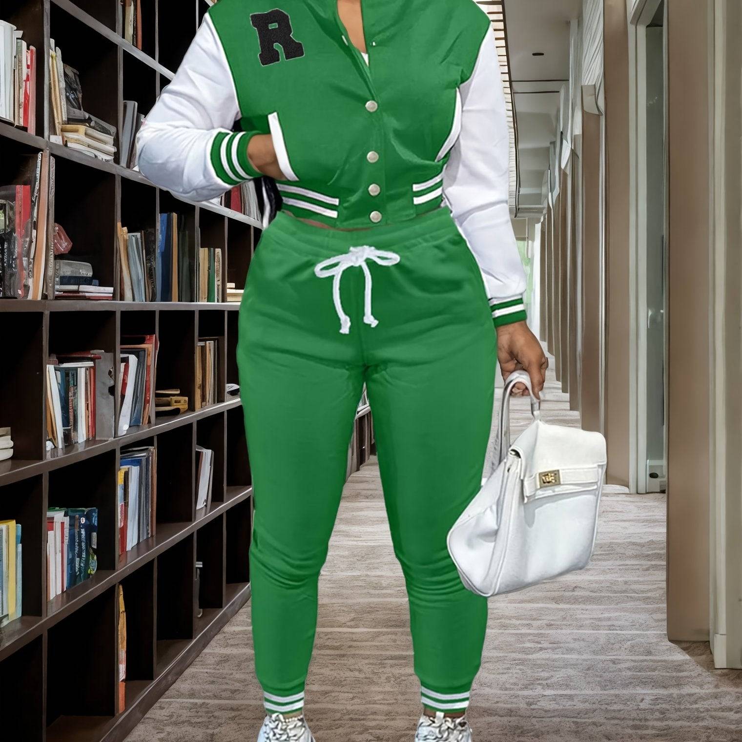 Green women’s 2-piece sportswear set with varsity jacket and jogger pants, styled for a sporty and fashionable look in a library setting.