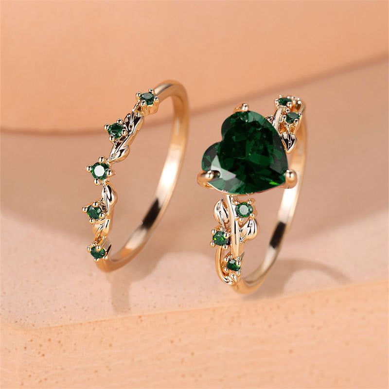 Heart-shaped gold-plated ring set for women with green cubic zirconia stones, featuring a vintage design. Includes two romantic emerald-toned rings.