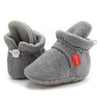 Gray newborn shoes with red tag and soft soles