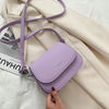 Lavender vintage PU leather crossbody bag on beige fabric