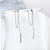 Close-up of long tassel earrings with textured metal chain