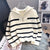 Striped white and black women's pullover sweater with zipper