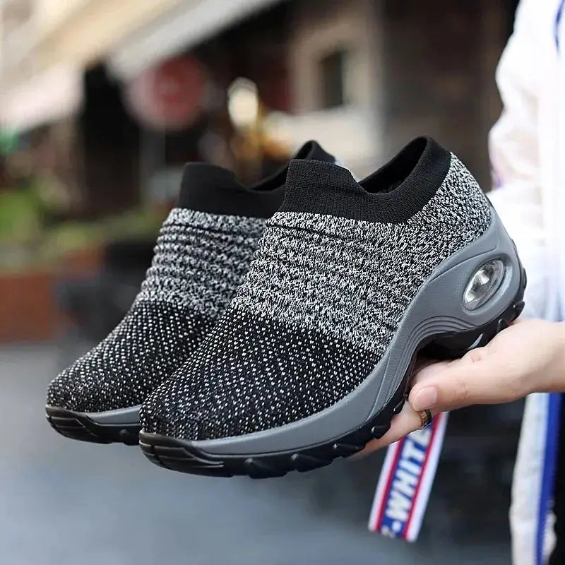 Gray and black speckled women's slip-on sock sneakers with air cushion sole, breathable mesh for walking, casual wear or fitness workouts.