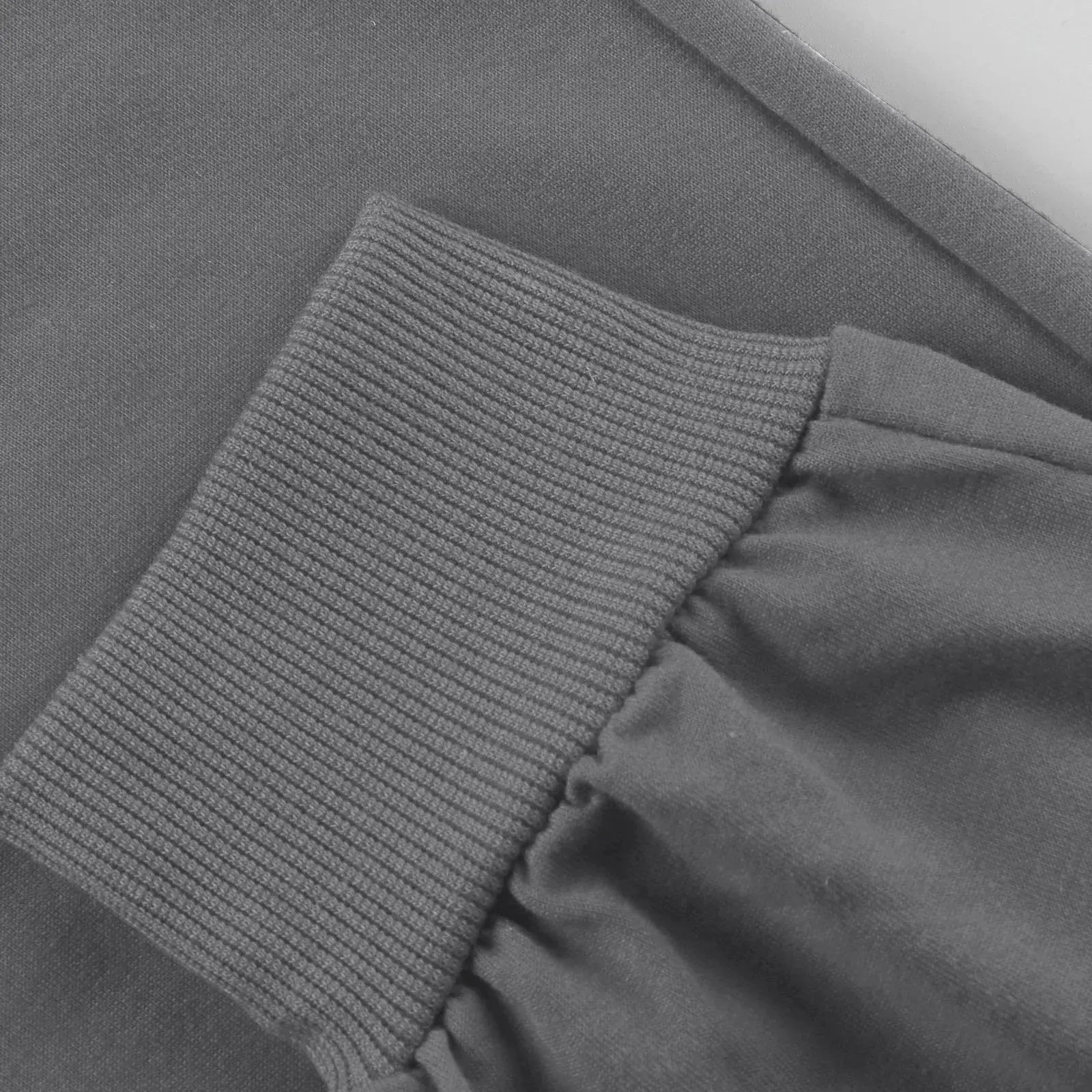 Detailed view of ribbed ankle cuff on gray men’s athletic jogger sweatpants, designed for comfort and secure fit during workouts or running.