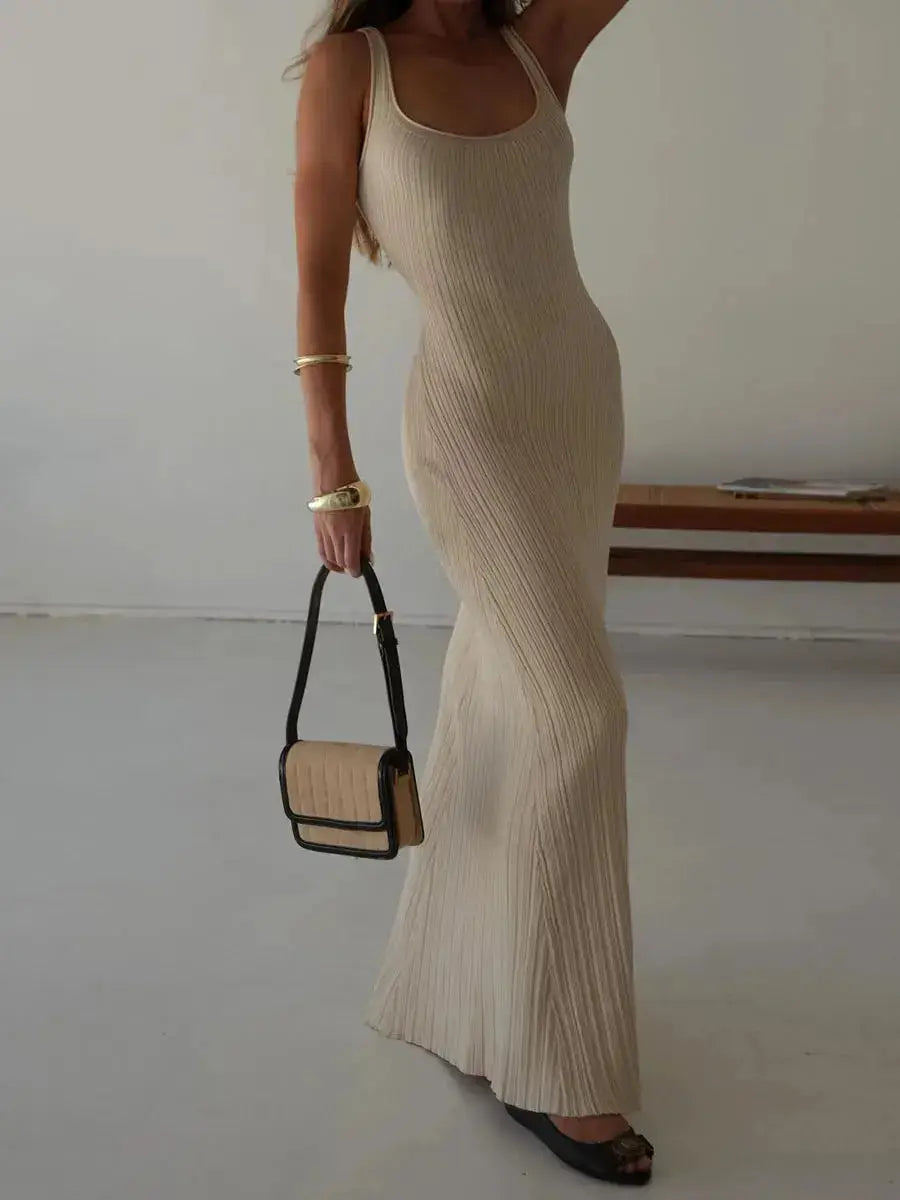 Elegant women’s sleeveless knit tank dress in beige, styled with a handbag and jewelry, perfect for summer events and beachwear.