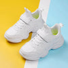 White children's shoes on colorful background