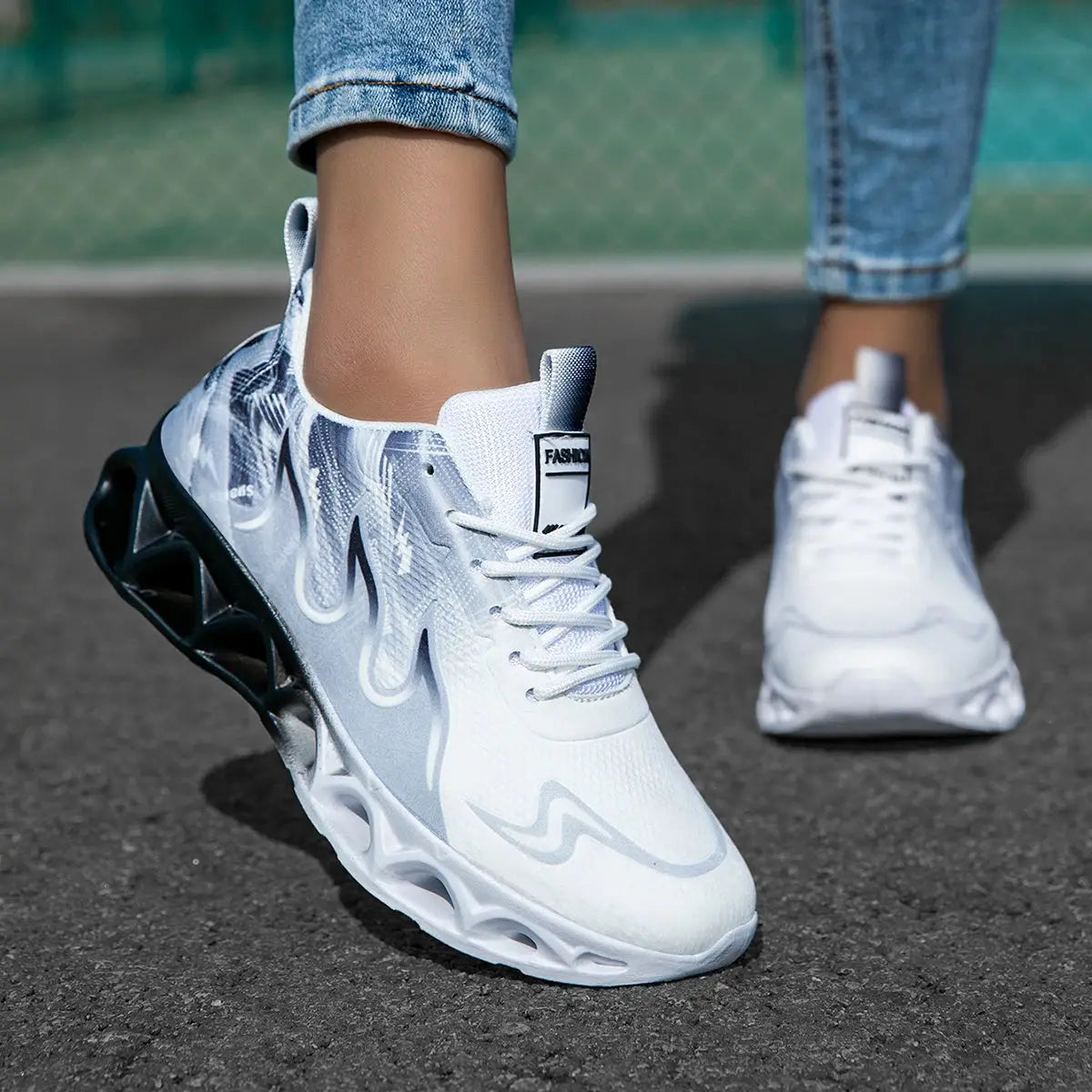 White and black women's running sneakers with breathable mesh and soft blade sole, designed for comfort during jogging or casual use.