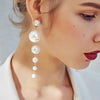 Long cascading pearl dangle earrings worn by a model