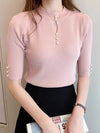 Pink ribbed women's sweater with pearl buttons.