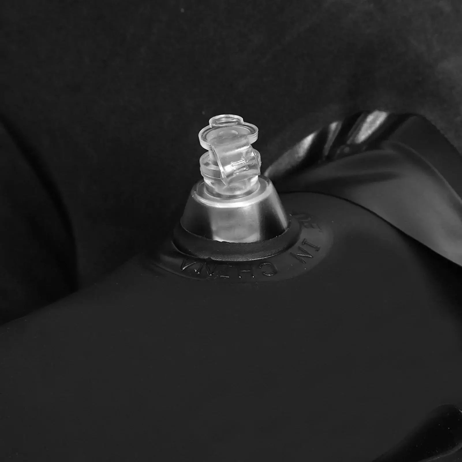 Inflation valve detail on black inflatable air mattress for car back seat, showing easy setup for travel and camping use.