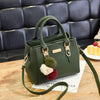 Green faux leather handbag with pom-pom charms