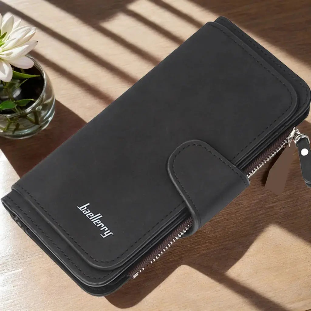 Black women's long trifold wallet with sleek finish, featuring a zippered section and snap closure for secure storage.