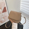 Beige vintage PU leather crossbody bag on black table