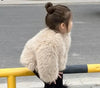 Girl wearing fluffy winter coat on street