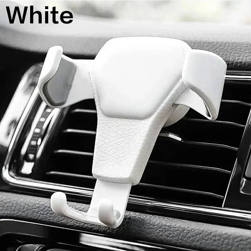 White universal gravity phone holder clipped to car air vent, featuring leather-textured surface and curved grip arms.