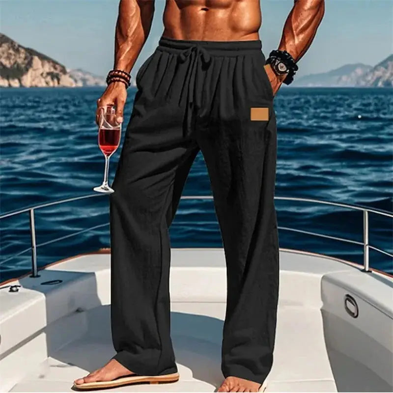 Men’s breathable drawstring pants with elastic waist in black, styled for beach or yacht wear with a relaxed fit and casual vibe.
