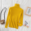 Yellow women's turtleneck sweater on bed