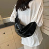 Black shoulder bag worn by person in white