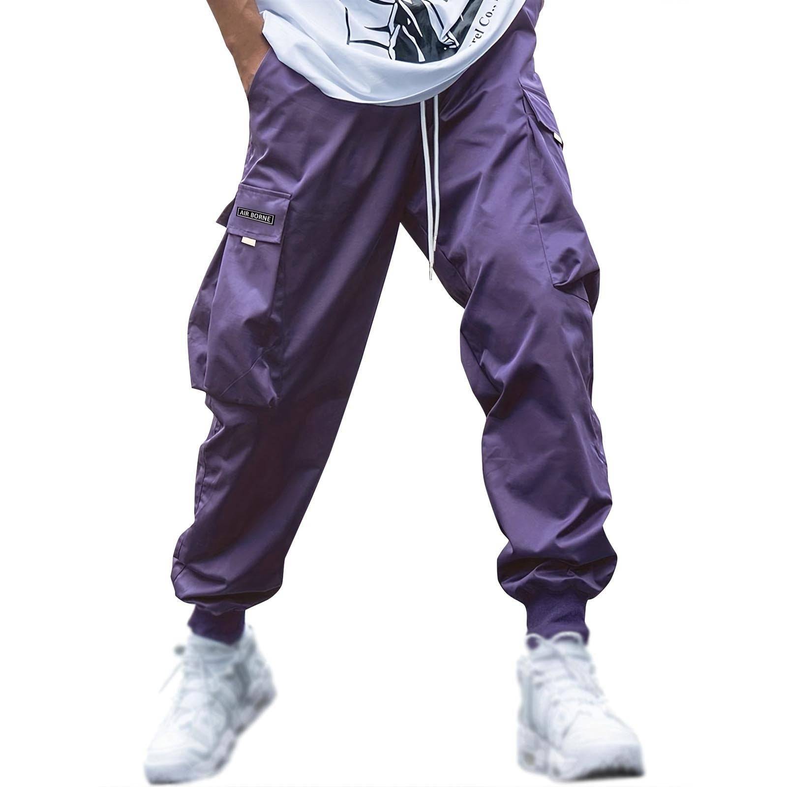 Vibrant purple men’s cargo jogger pants with drawstring and utility pockets, great for bold streetwear or casual fashion.