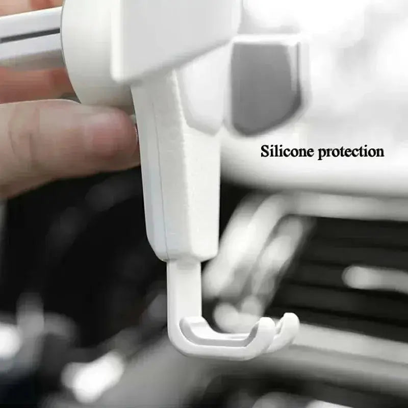 White universal gravity phone holder with silicone protection for scratch-free grip, designed for car air vent use.