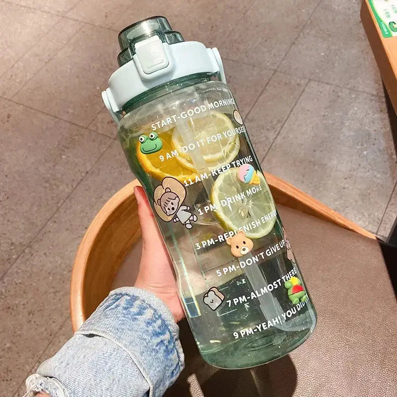 Green 2L hydration bottle with straw, hourly time markers, and cute animal stickers, perfect for summer water intake and fitness routines.