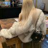 Woman wearing luxury fur coat with black bag