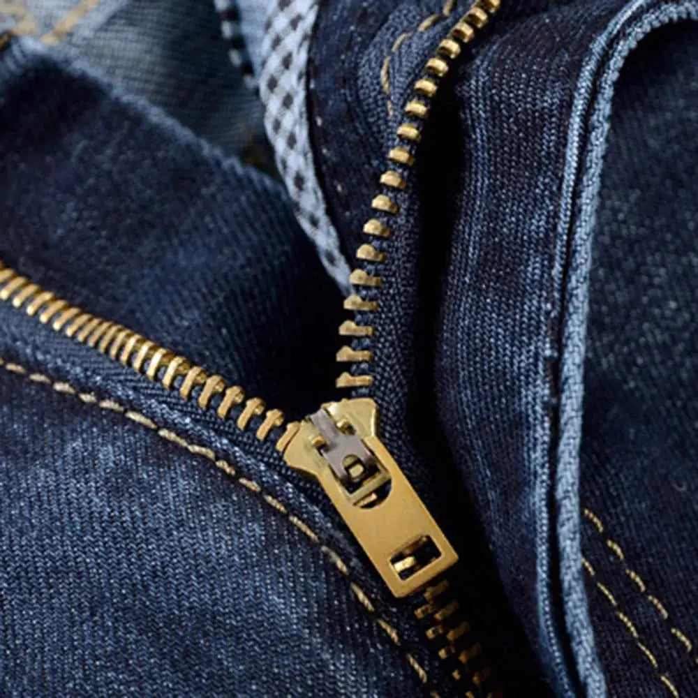 Detailed view of durable brass zipper on men’s stretch denim jeans, showcasing quality streetwear construction.