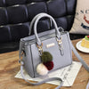 Gray faux leather handbag with pom-pom charms