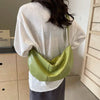 Green shoulder bag worn by person in white