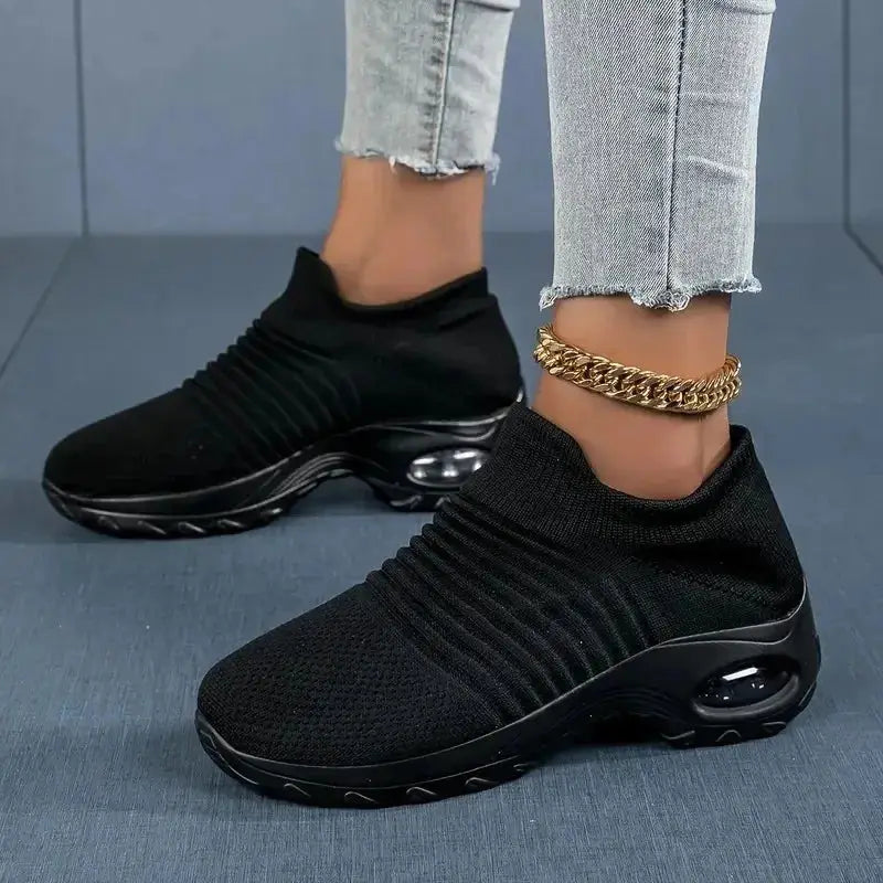 All-black women's slip-on sock sneakers with black air cushion sole, lightweight mesh for walking, casual wear or gym training sessions.