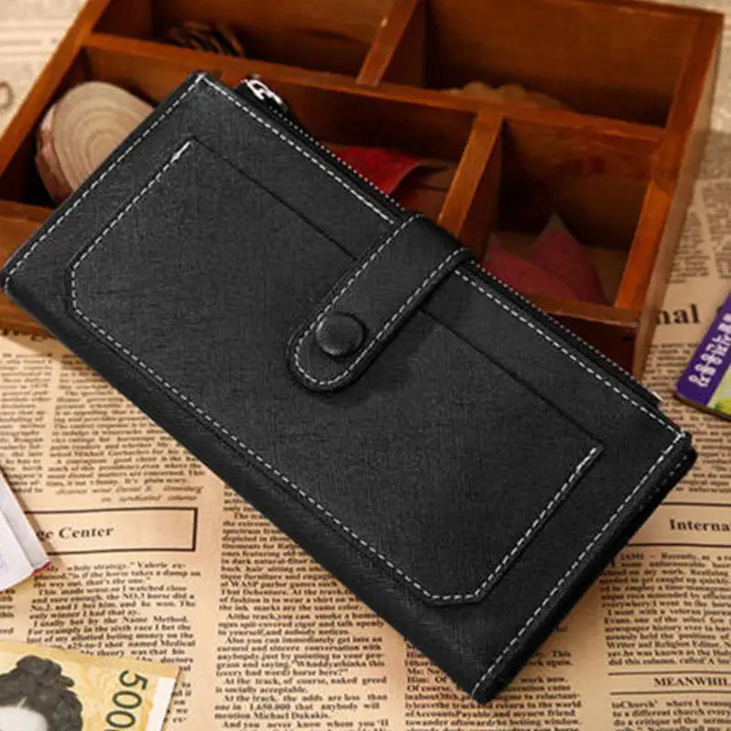 Black women's PU leather bifold long wallet with buckle closure and zippered compartment, styled on a rustic newspaper background.