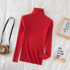 Red women's turtleneck sweater on bed