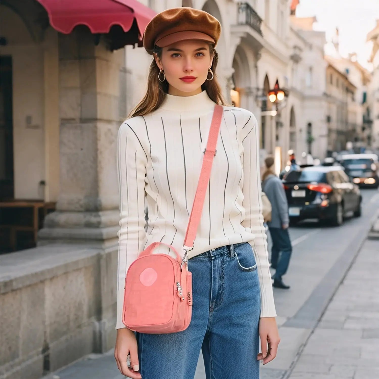 Woman wearing pink lightweight crossbody bag with adjustable strap, styled casually for everyday use in urban setting.