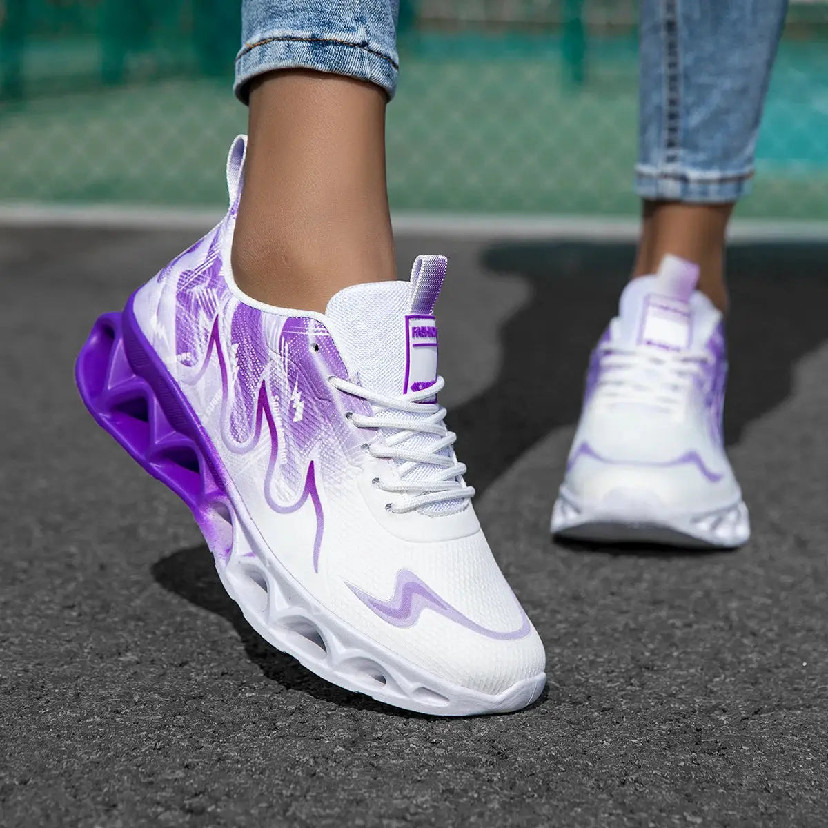 Women's lightweight sneakers in white and purple with breathable mesh and cushioned blade sole, perfect for running or daily activities.