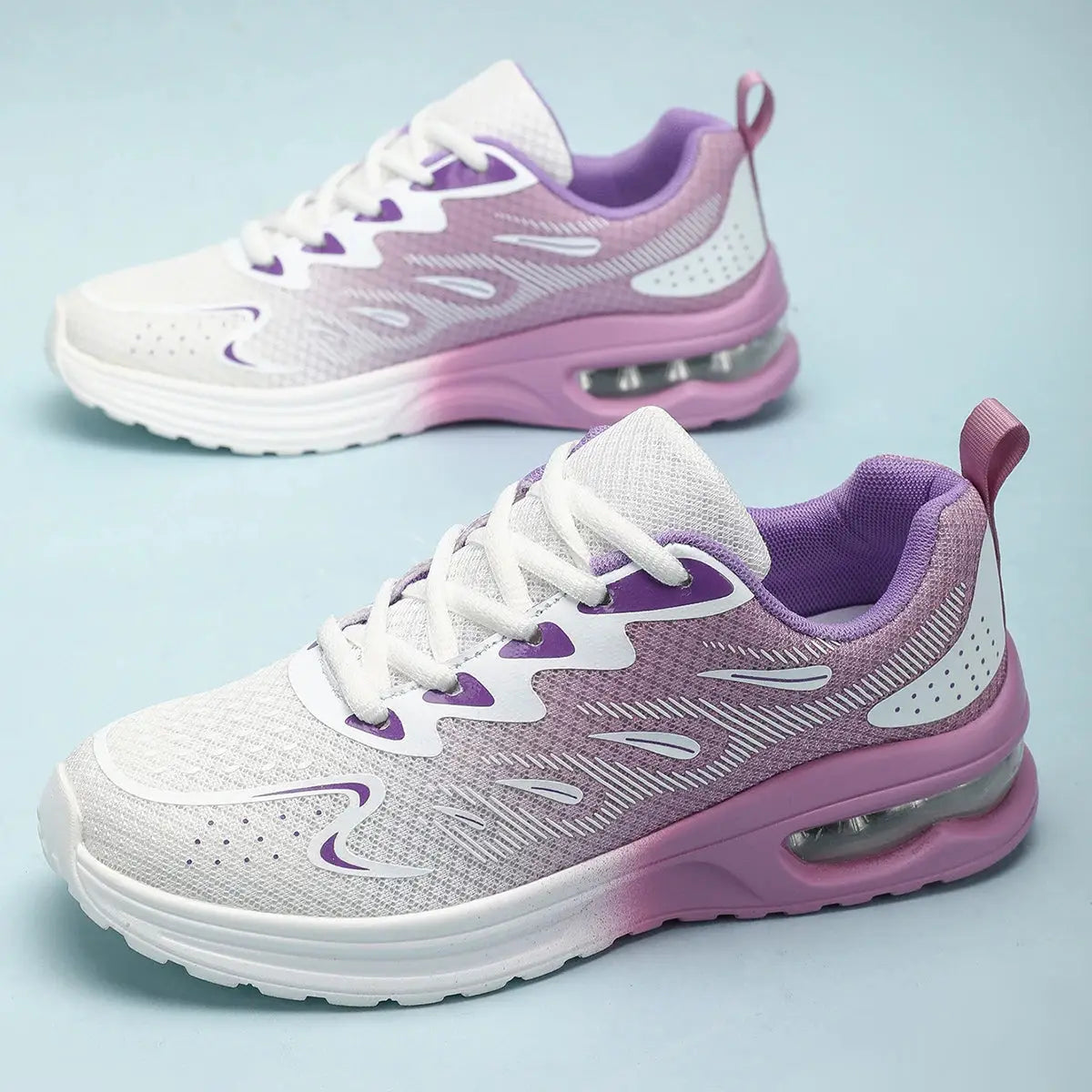 Purple and white women's sneakers with breathable knit upper and cushioned sole, designed for walking or running comfort.