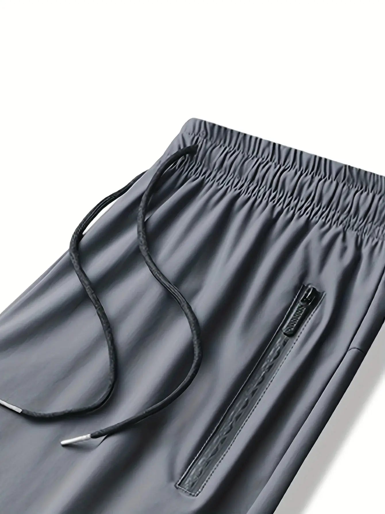 Detail of grey Mens Quick-Dry Training Pants waistband with drawstring and zipper pocket, highlighting comfort and utility for workouts.