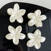 Pearl white flower hair clips on black surface