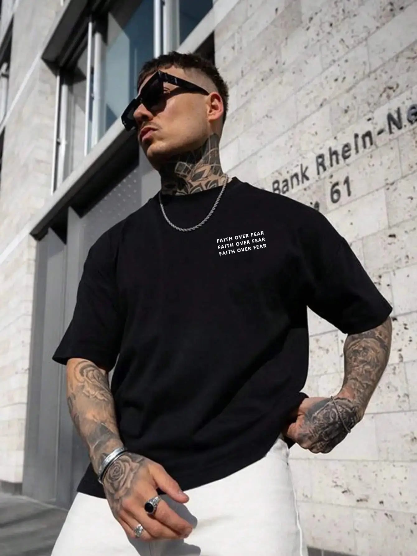 Black cotton t-shirt for men with 'Faith Over Fear' text, styled casually.