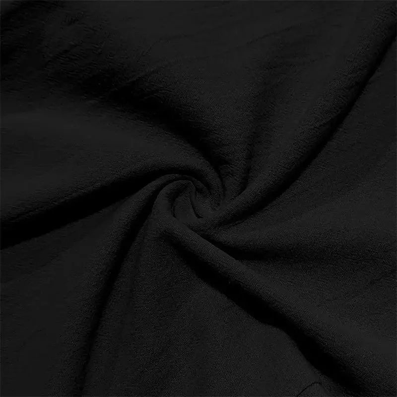 Close-up of black waffle-textured cotton fabric used in men's lightweight linen pants with drawstring and pockets for summer casual wear.