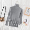 Gray women's turtleneck sweater on bed