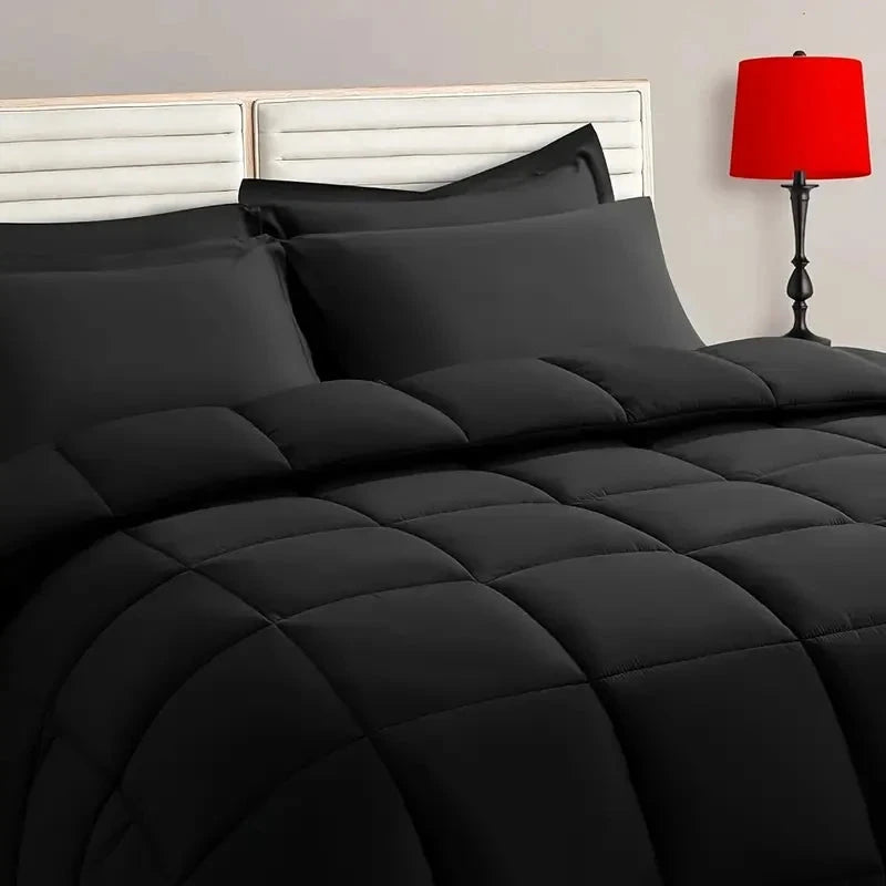 All-black reversible microfiber comforter bedding set with matching pillow shams, showcasing smooth texture and quilted design.