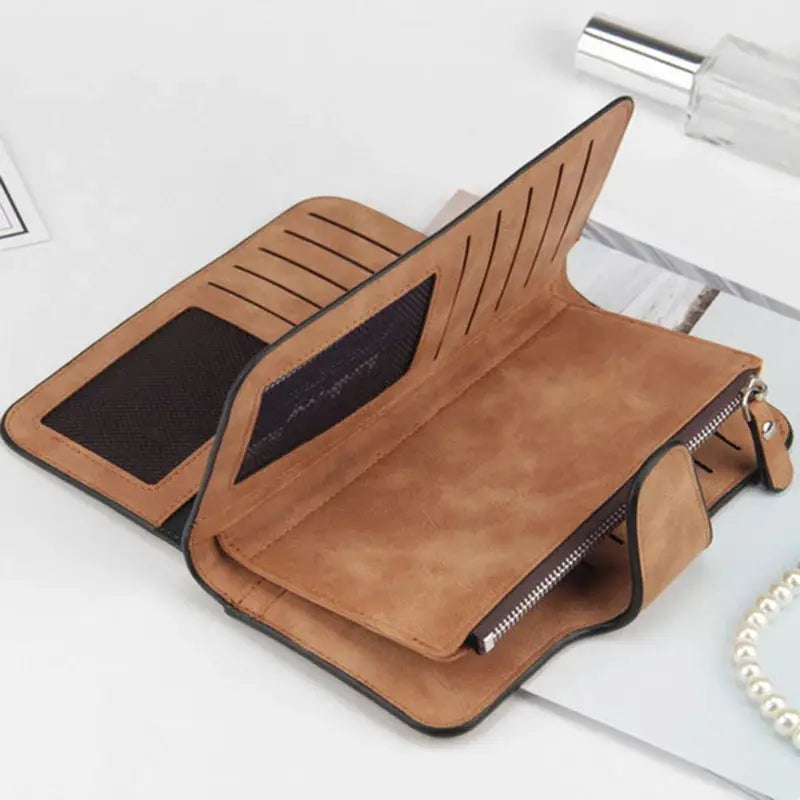 Interior view of brown women's long trifold wallet showing multiple card slots, zippered pocket, and cellphone compartment.