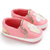 Pink baby shoes with gold accents