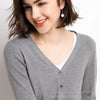 Smiling woman in gray cardigan.