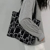 Person carrying black cat print handbag