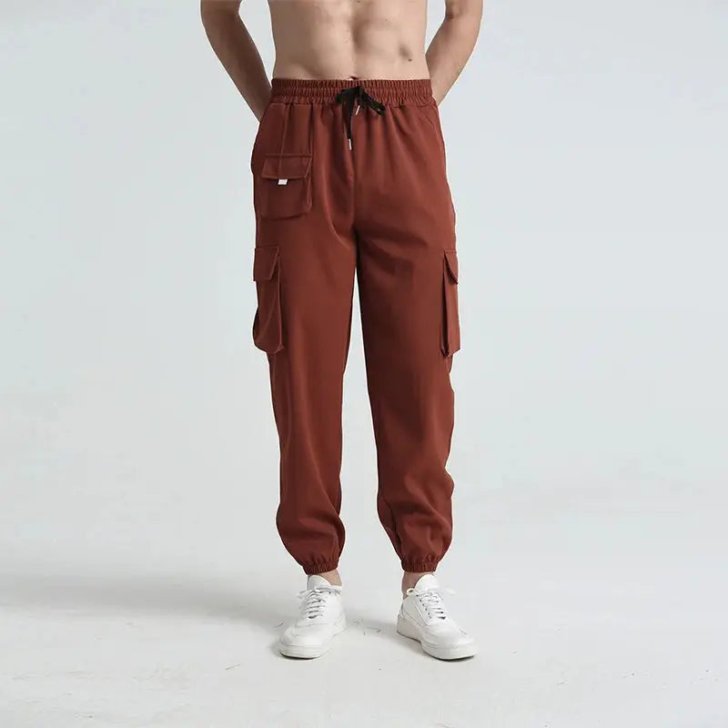 Rust-colored men’s cargo hiking pants with breathable, quick-dry fabric and adjustable waistband, perfect for hiking and casual wear.
