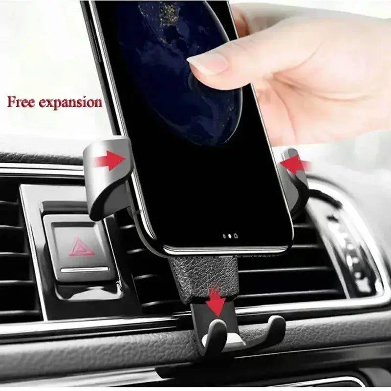 Smartphone being placed into universal gravity phone holder with automatic grip expansion, mounted on car air vent.
