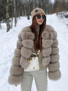 Woman in beige faux fur coat in snowy forest