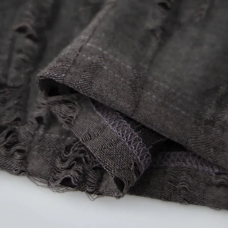 Hem detail of charcoal gray men’s short sleeve T-shirt with worn-look texture, emphasizing quality stitching and casual style.