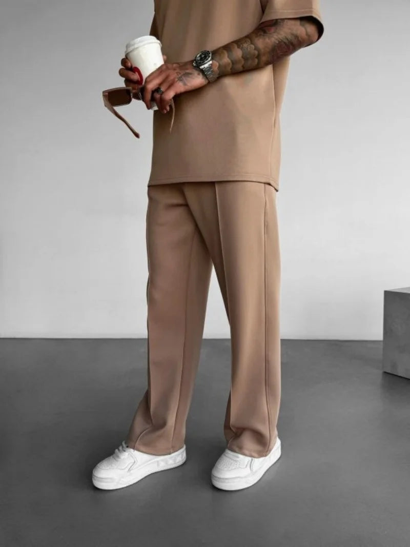 Beige men's casual pants with elastic waist and relaxed fit.